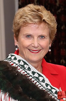 Dame Diana Crossan, former Retirement Commissioner. Wearing a red jacket and Maori kakahu.