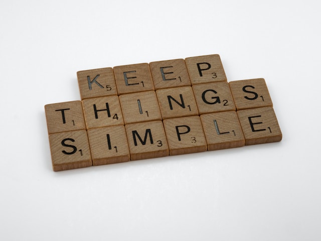 "Keep Things Simple" written with brown Scrabble letter tiles. KEEP is on the top line, THINGS is beneath, and SIMPLE is under that. So three rows in all.