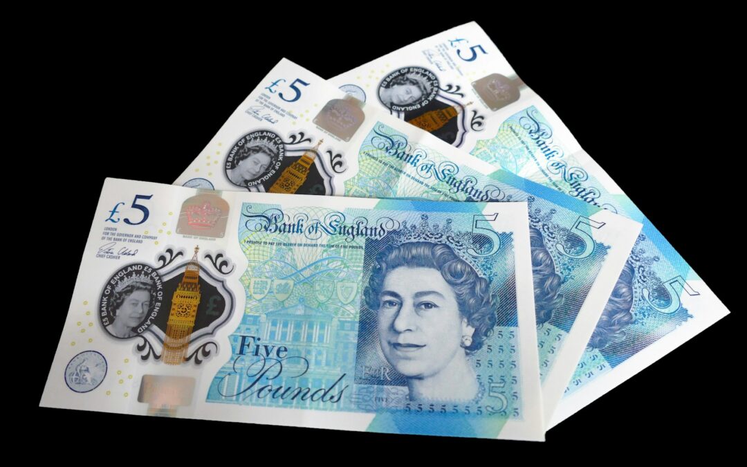 Three five pound notes, fanned out flat . Blue in colour, a picture of the queen on the front.